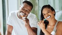 a couple brushing their teeth together